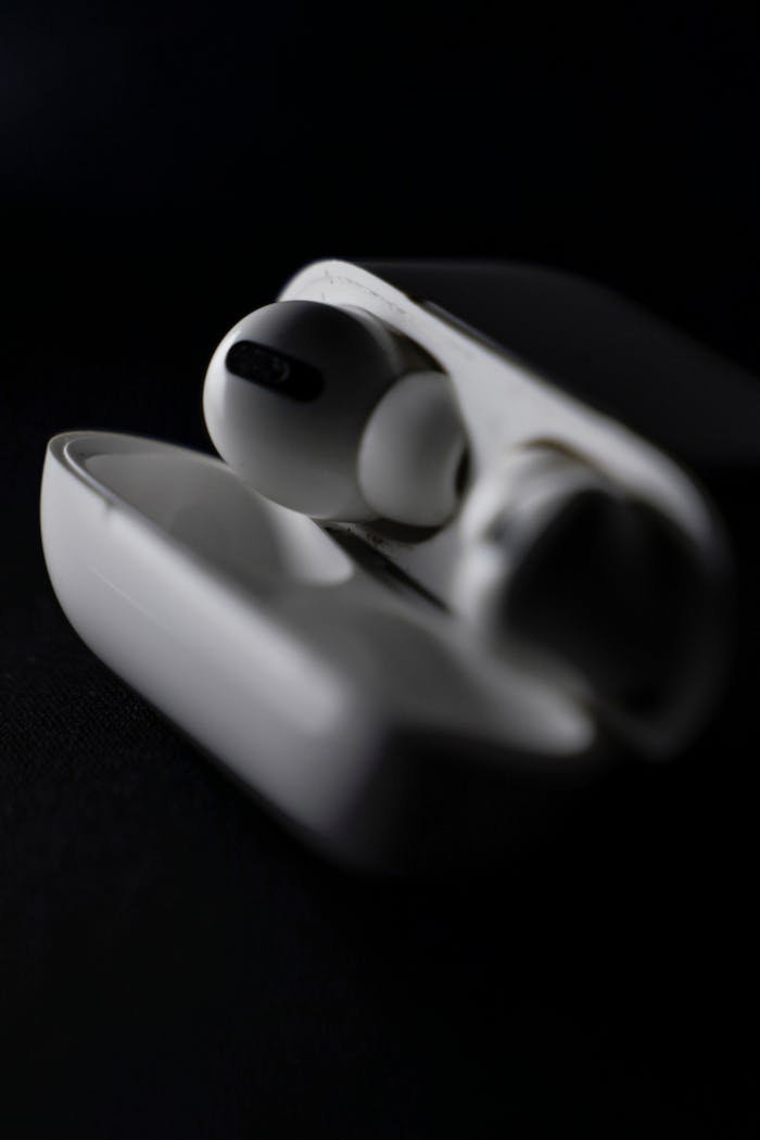 Detailed shot of wireless earphones in a sleek, modern case on a dark background.